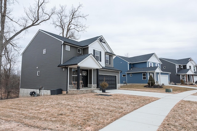 view of front of property with an attached garage, covered porch, concrete driveway, roof with shingles, and a residential view