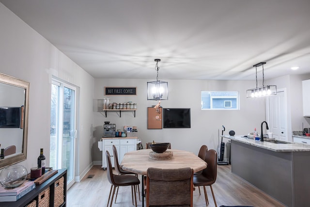 dining area featuring baseboards, visible vents, and light wood-style floors