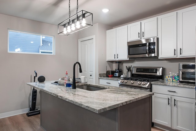 kitchen featuring light stone countertops, a kitchen island with sink, stainless steel appliances, and a sink