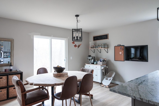 dining space with light wood-style flooring and baseboards