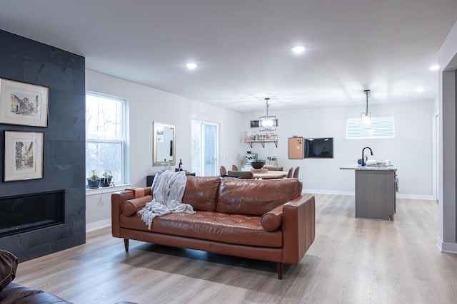 living area with recessed lighting, light wood-style flooring, and baseboards