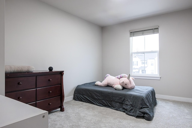 bedroom with light carpet and baseboards