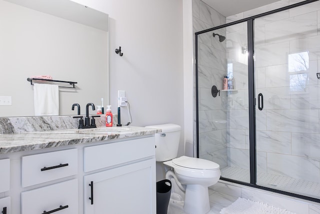 full bathroom with toilet, marble finish floor, vanity, and a stall shower