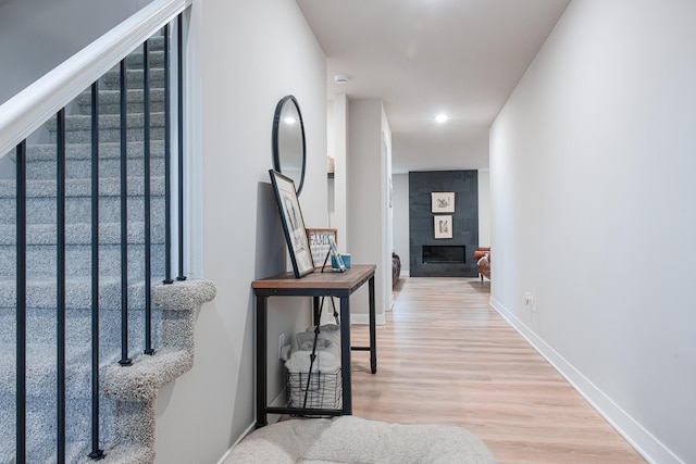 hall with wood finished floors, baseboards, and stairs