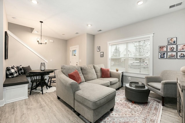 living room featuring recessed lighting, visible vents, light wood finished floors, and an inviting chandelier