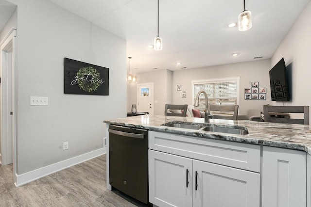 kitchen with a sink, white cabinetry, light wood-type flooring, light stone countertops, and dishwasher