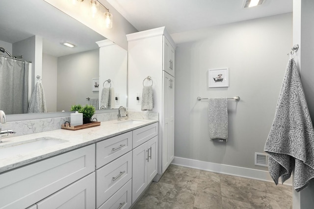 full bathroom featuring double vanity, visible vents, baseboards, and a sink