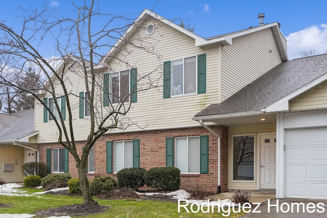 traditional-style home with a shingled roof, brick siding, and an attached garage