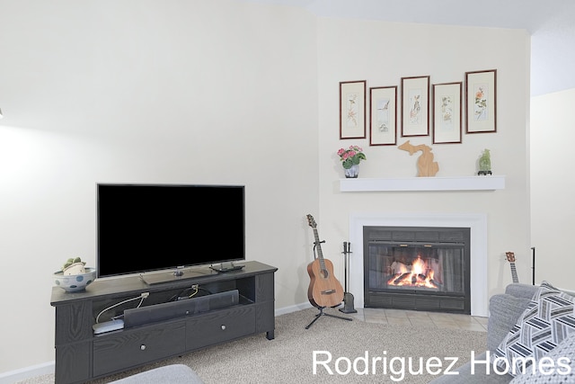 carpeted living room with a fireplace with flush hearth and baseboards