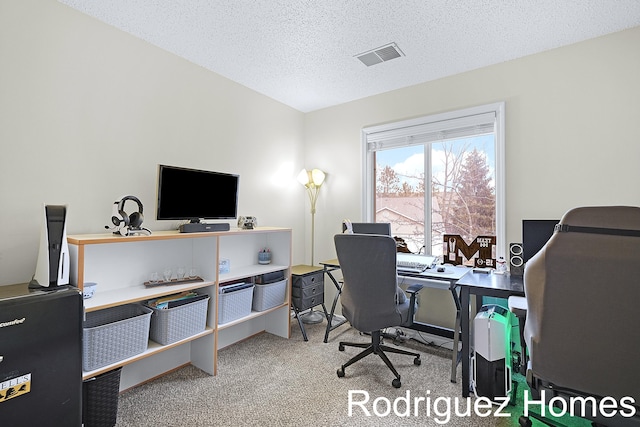 office space featuring carpet, visible vents, and a textured ceiling