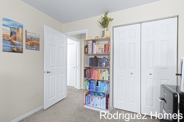 rec room featuring a textured ceiling, baseboards, and carpet flooring