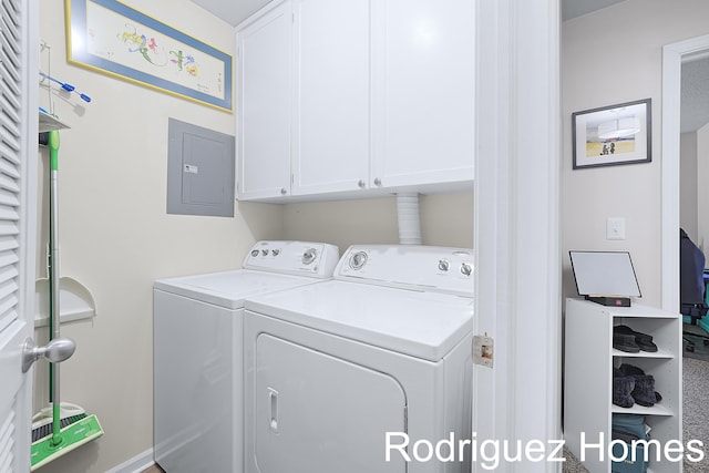 laundry room with washer and clothes dryer, cabinet space, and electric panel