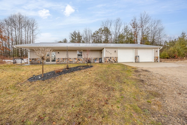 single story home with a garage, dirt driveway, stone siding, metal roof, and a front yard