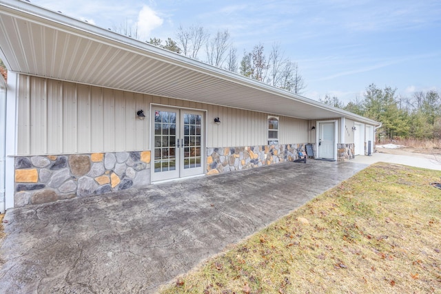 exterior space featuring stone siding and french doors