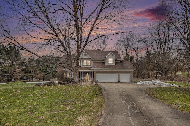 traditional home with brick siding, a yard, and driveway