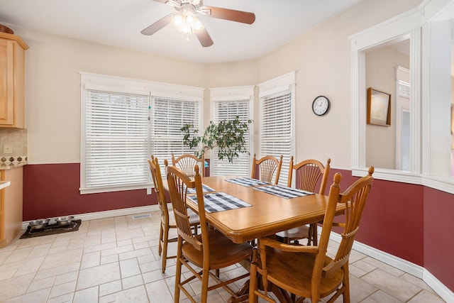 dining space featuring ceiling fan and baseboards