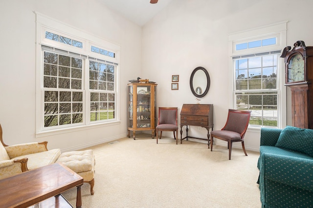 living area featuring lofted ceiling, carpet floors, visible vents, and baseboards