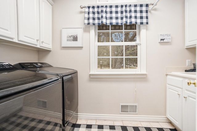 laundry room with separate washer and dryer, cabinet space, visible vents, and baseboards