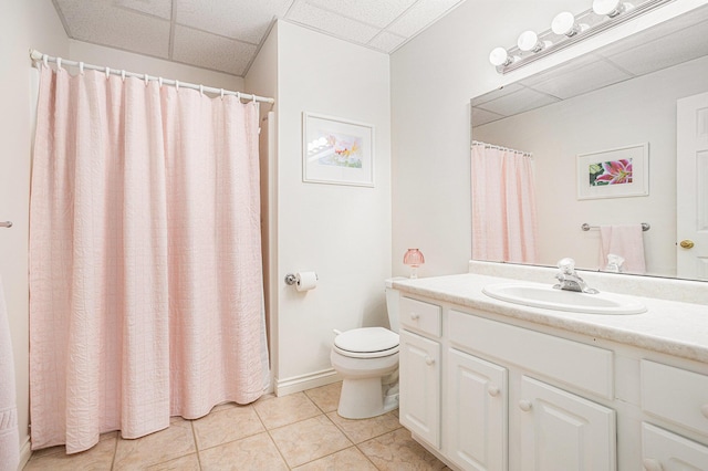 full bath featuring a paneled ceiling, vanity, toilet, and tile patterned floors