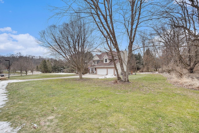 view of yard featuring driveway and an attached garage