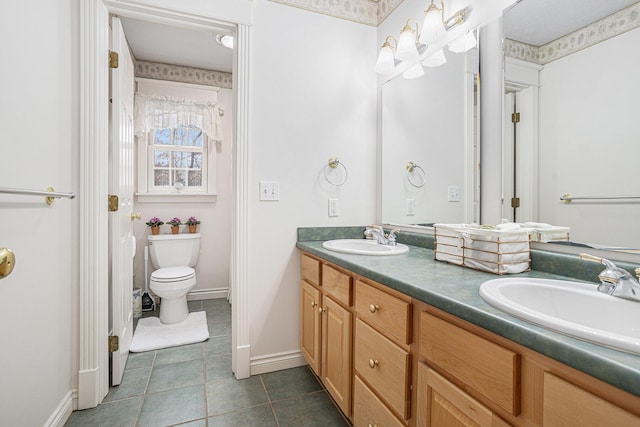 bathroom with double vanity, tile patterned flooring, a sink, and toilet