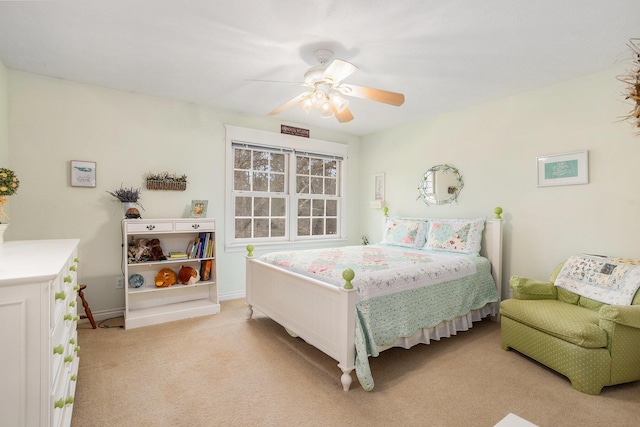 bedroom with light carpet, ceiling fan, and baseboards