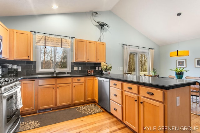 kitchen with visible vents, light wood-style flooring, appliances with stainless steel finishes, a sink, and a peninsula