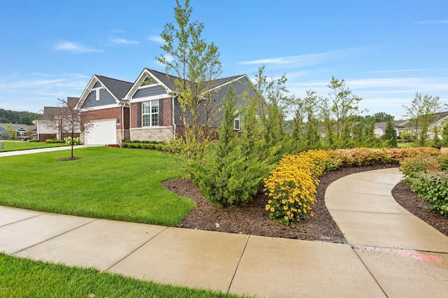 view of front of home featuring a garage, driveway, brick siding, and a front yard