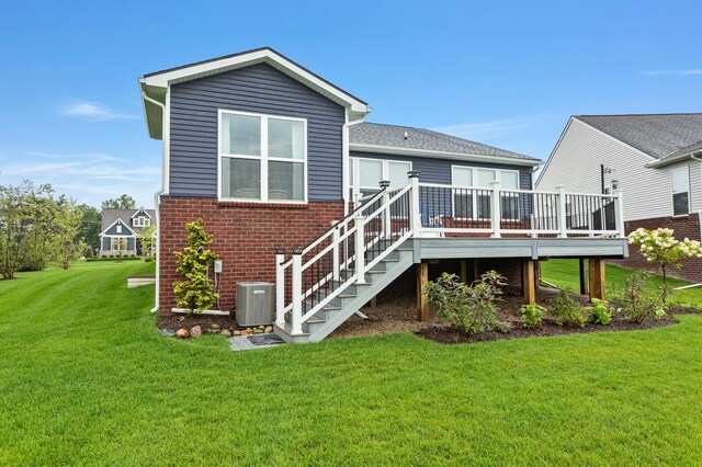 back of house featuring brick siding, a yard, a deck, cooling unit, and stairs