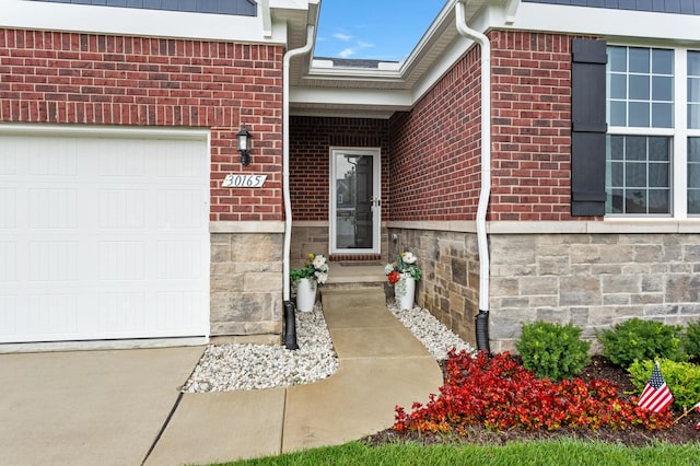 doorway to property with brick siding and an attached garage