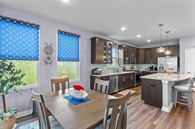 dining room with recessed lighting, baseboards, and light wood finished floors