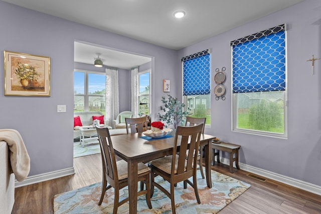 dining area with visible vents, baseboards, and wood finished floors