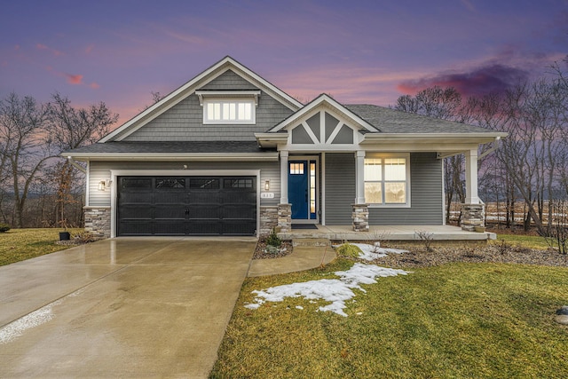 craftsman-style home featuring roof with shingles, covered porch, an attached garage, stone siding, and driveway