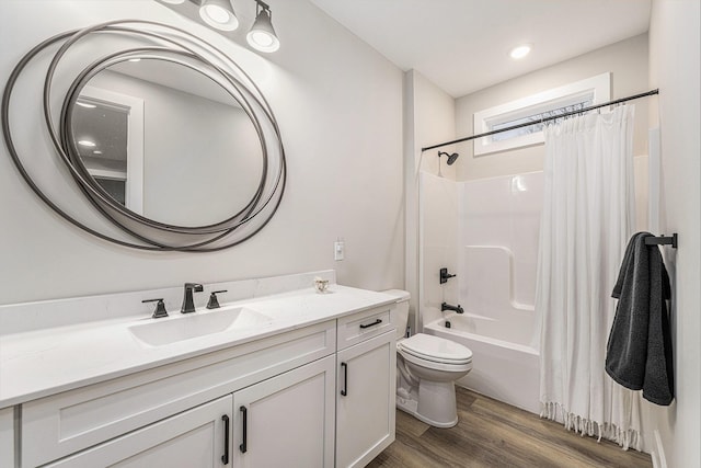 bathroom with toilet, shower / bath combo with shower curtain, wood finished floors, and vanity