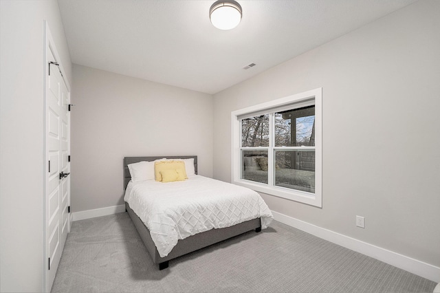 carpeted bedroom featuring visible vents and baseboards