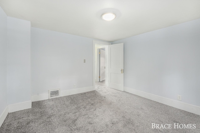 spare room with baseboards, visible vents, and carpet flooring