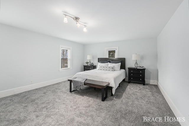 bedroom featuring carpet floors, track lighting, and baseboards