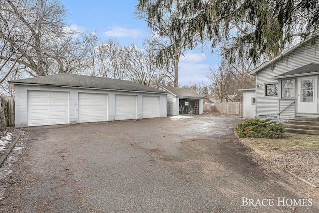 detached garage featuring fence