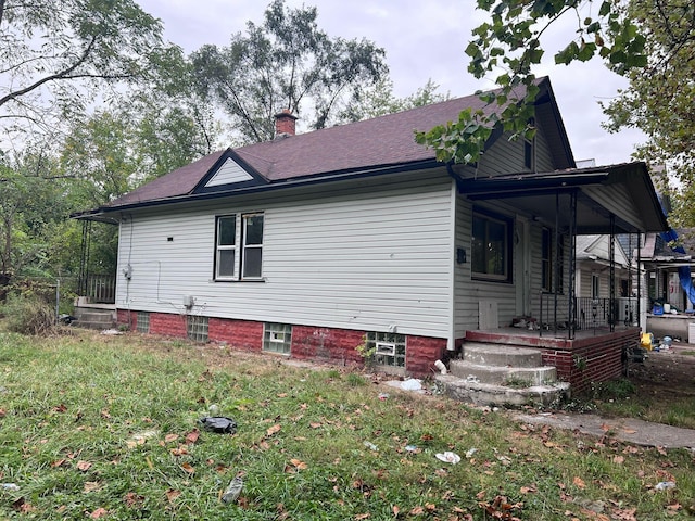 view of home's exterior featuring a porch and a chimney