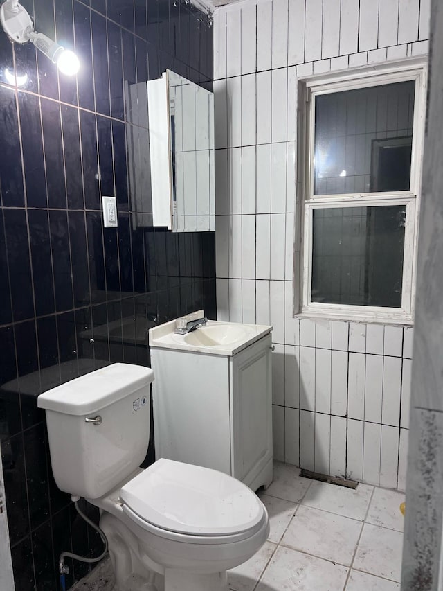 bathroom featuring toilet, tile walls, and vanity