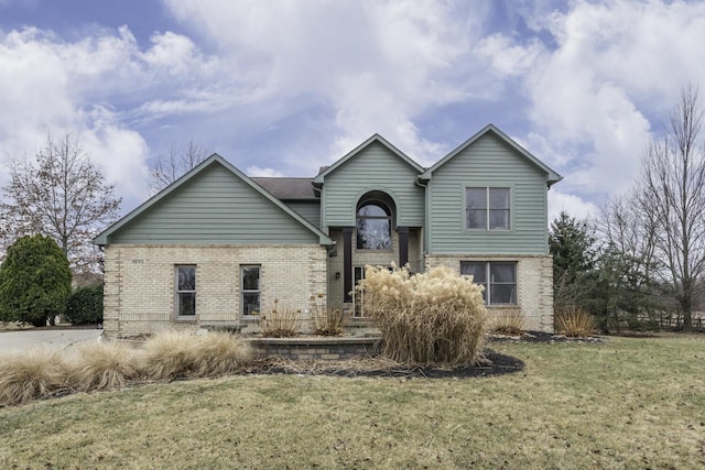 view of front of home featuring a front lawn and brick siding