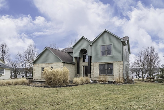 view of front of house featuring brick siding and a front lawn