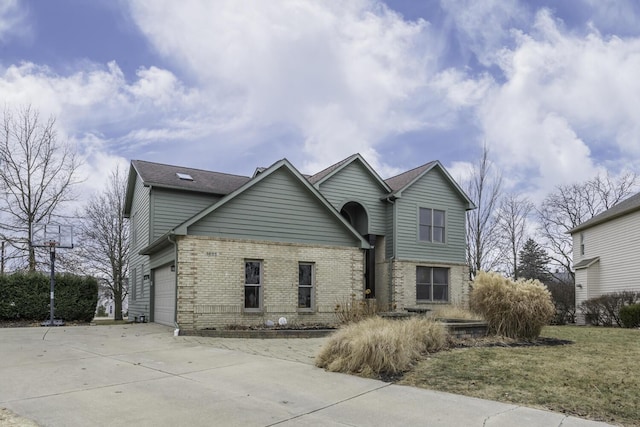 traditional home featuring concrete driveway, brick siding, and an attached garage