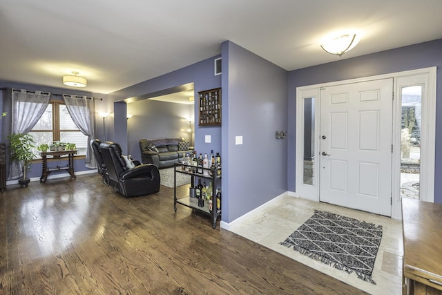 entrance foyer featuring wood finished floors, visible vents, and baseboards