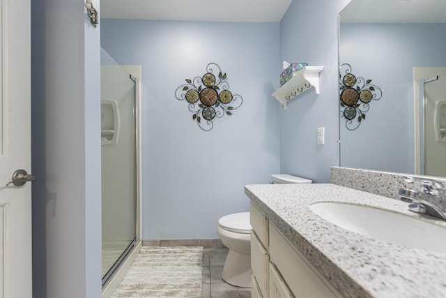 bathroom featuring toilet, a stall shower, tile patterned flooring, and vanity