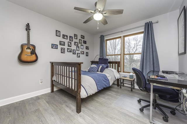 bedroom featuring ceiling fan, baseboards, and wood finished floors