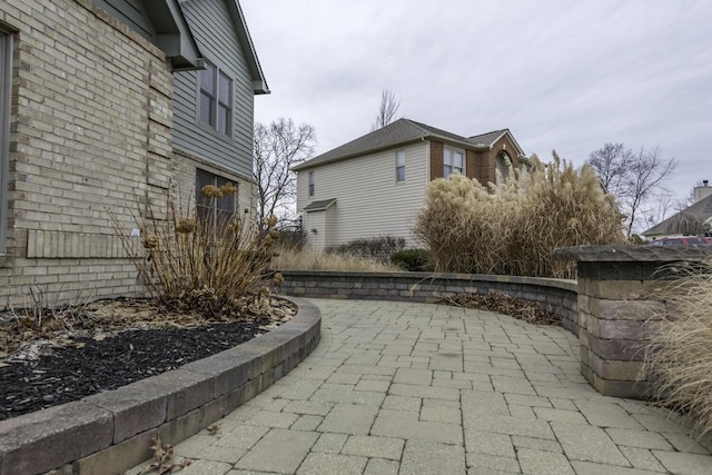 view of side of property featuring a patio area and brick siding