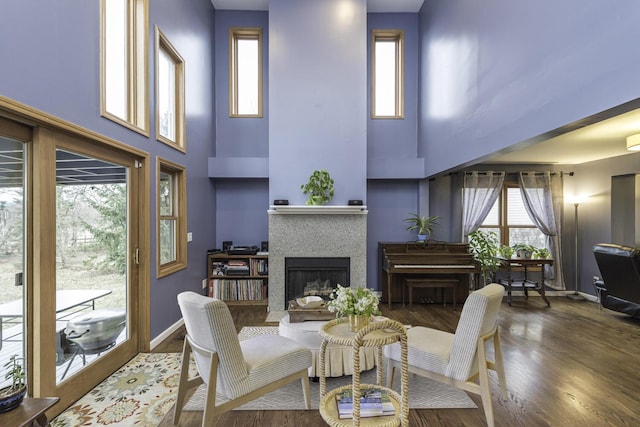 living area with a fireplace, wood finished floors, and baseboards