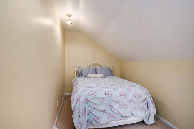 bedroom featuring carpet flooring, baseboards, and lofted ceiling