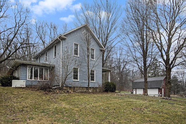 view of home's exterior with a detached garage and a lawn